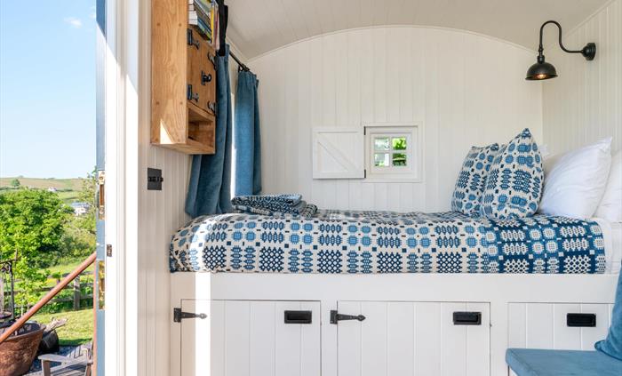 King-size bed with comfortable handmade mattress, handwoven traditional Welsh blankets and throws .
